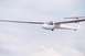 2003 Ford Crown Victoria - A white glider aircraft is captured in mid-flight against a cloudy sky.