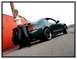 2002 Ford Mustang - A green 2002 Ford Mustang is shown from a rear 3/4 angle, with a woman posing next to it.