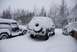 1996 Ford Bronco - Two SUVs are buried in snow during a winter storm, with a house visible in the background.