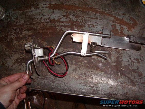Fuel pump assembly with metal lines and electrical connectors on a workbench