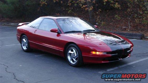 Red coupe with black hood and spoiler, chrome wheels, parked on asphalt