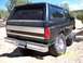 1994 Ford Bronco - This lifted Ford Bronco, likely a 1992-1996 model, is photographed from the rear-right on a dusty trail.