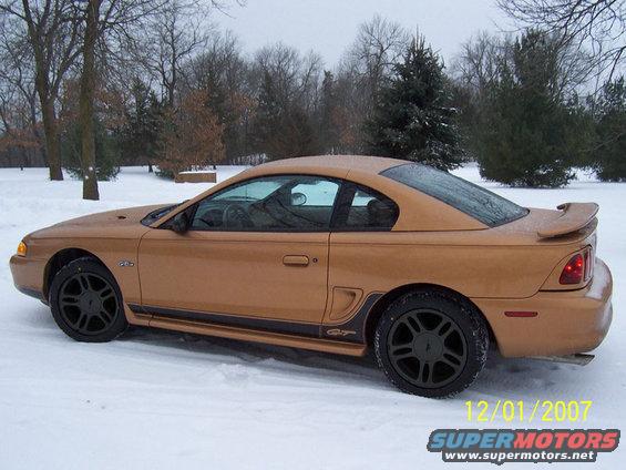 Gold 1994 Ford Mustang GT coupe parked in snow, side view