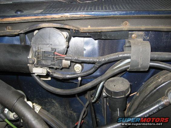 Close-up of a vehicle's windshield wiper motor and wiring harness