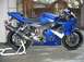 2005 Yamaha R1 - A blue sport motorcycle is parked on a stand with an aftermarket exhaust system.