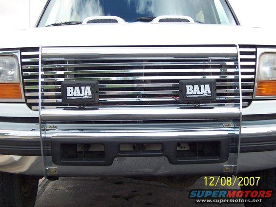 1996 Ford Bronco front grille with chrome bars and two Baja lights mounted on a brush guard