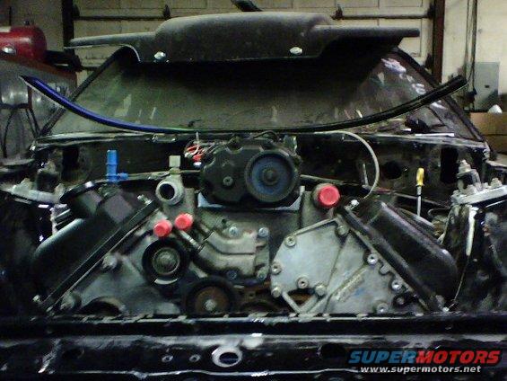engine bay with supercharger, intake manifold, and engine block visible
