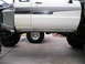 1986 Toyota Hilux - Side view of a white pickup truck black graphics and protective rock sliders.