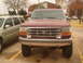 1992 Ford Bronco - A maroon Ford truck is parked outside next to a silver SUV on a cloudy day.