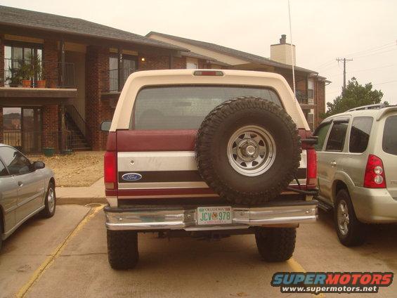 1992 Ford Bronco rear view, showing spare tire mounted on tailgate and a silver SUV parked to the right
