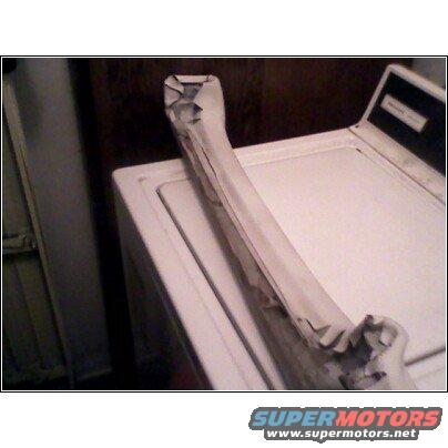 Taped car part on top of a washing machine