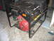1996 Dodge 2500 - A portable generator with a Honda engine is shown from the side. It has a black metal frame and a control panel with various outlets.