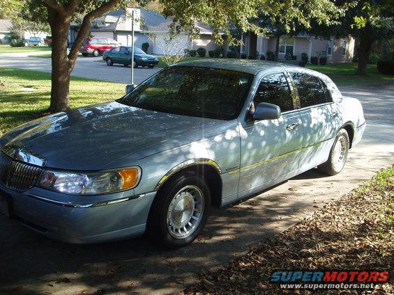 Light blue 1998 Lincoln Town Car parked on a driveway, seen from the front quarter