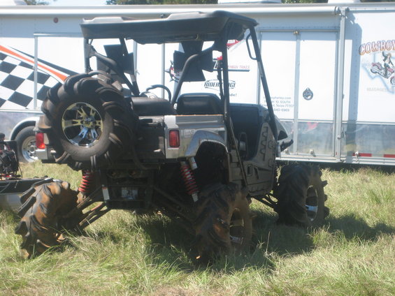 Rear view of a mud bogging ATV with a spare tire mounted on the back