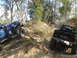 1989 Ford Bronco - Several off-road vehicles navigate a steep, dusty incline surrounded by trees.