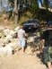 1989 Ford Bronco - An SUV navigates a rocky off-road course with two onlookers observing the challenging terrain.