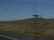 1995 Ford C-350 (Centurion Conversions) - A dinosaur statue stands on a hill overlooking a road.