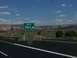 1995 Ford C-350 (Centurion Conversions) - A highway exit sign indicates exit 354, with a vast landscape of mesas under a cloudy sky.