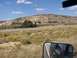 1995 Ford C-350 (Centurion Conversions) - Driving through a desert landscape with a prominent mesa under a blue sky with scattered clouds.