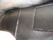 1993 Ford Taurus - Close-up view of a vehicle's undercarriage, revealing welded seams and a dark, textured protective coating.