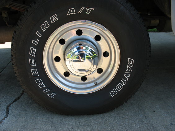 Close-up of a Dayton Timberline A/T tire on a chrome wheel with a chrome hubcap