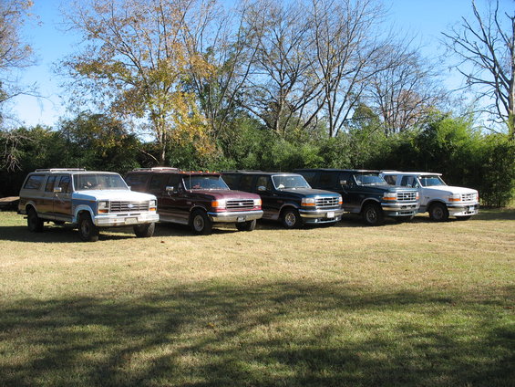Several Ford Bronco Centurion Conversions parked in a grassy area