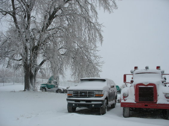 1995 Ford Explorer front view in snow, with a red fire truck and semi-truck in background