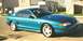 1994 Ford Mustang - A teal 1994 Ford Mustang GT coupe is parked on a residential street.