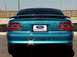 1994 Ford Mustang - The rear of a teal Ford Mustang GT shows its distinctive taillights and 'Mustang GT' badging.