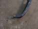 1995 Ford C-350 (Centurion Conversions) - A close-up view of a damaged blue metal automotive part resting on a concrete surface.