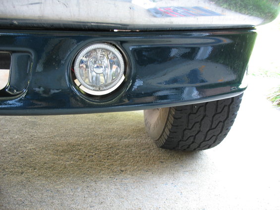 Dark green front bumper with fog light and tire visible