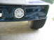 1995 Ford C-350 (Centurion Conversions) - Close-up of a dark green front bumper, showing a fog light and part of a tire.