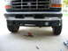 1995 Ford C-350 (Centurion Conversions) - Front view of a Ford truck, showing the grille and bumper with tools nearby.