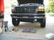 1995 Ford C-350 (Centurion Conversions) - Front valance of a 1995 Ford C-350 (Centurion Conversions) with fog lights, tools on the ground.