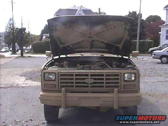 Tan 1985 Ford Bronco front view, hood open