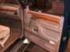 1995 Ford C-350 (Centurion Conversions) - Close-up of a vehicle's interior door panel and part of the seat, showing wood accents and controls.