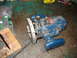 1995 Ford C-350 (Centurion Conversions) - A blue Ryobi router with a 1.75 HP label sits on a dusty floor next to a circuit board and a piece of wood.