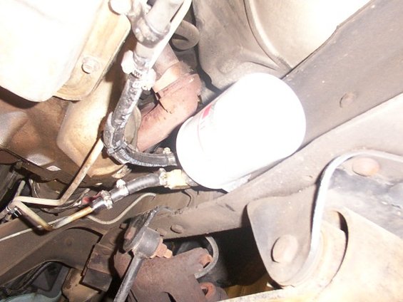 Transmission fluid filter and hoses attached to vehicle frame