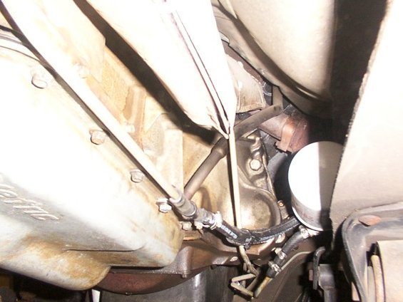 Underside view of vehicle transmission housing and oil filter with hoses