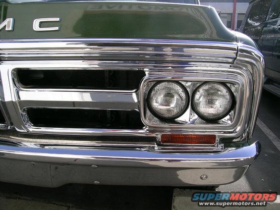 Green GMC truck front end with chrome grille and dual headlights