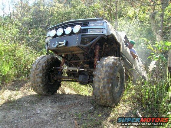 Modified truck with large tires and winch, driving off-road