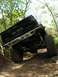 1989 Ford Bronco - A modified Chevrolet pickup truck navigates a challenging off-road trail through a wooded area.
