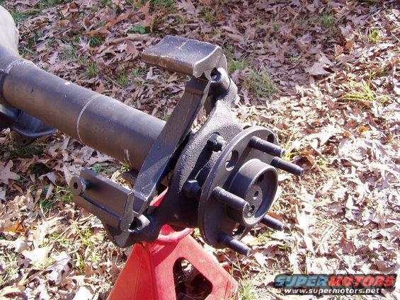 Close-up of a truck axle assembly, likely from a Ford F-250, resting on a red jack stand outdoors
