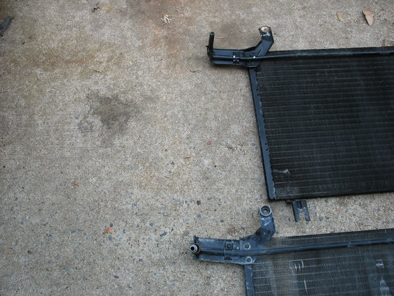 Two car AC condensers sit on a concrete surface