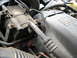 1995 Ford C-350 (Centurion Conversions) - Close-up view of engine components, including an AC compressor and a diesel engine cover.