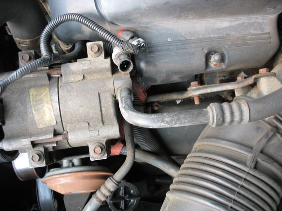 AC compressor and hoses in engine bay