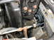 1995 Ford C-350 (Centurion Conversions) - Close-up view of AC condenser lines, showing some text on a hose.