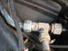 1995 Ford C-350 (Centurion Conversions) - This is a close-up view of a metal fitting connecting two AC lines in a vehicle's engine bay.