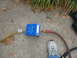 1995 Ford C-350 (Centurion Conversions) - A blue air vacuum pump is set up on a concrete surface with hoses attached.