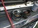 1995 Ford C-350 (Centurion Conversions) - Close-up of two pulleys, one new and one old, in an engine bay with a red hose and lubricant.